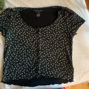 Black top with white floral print. Cropped and soft.
